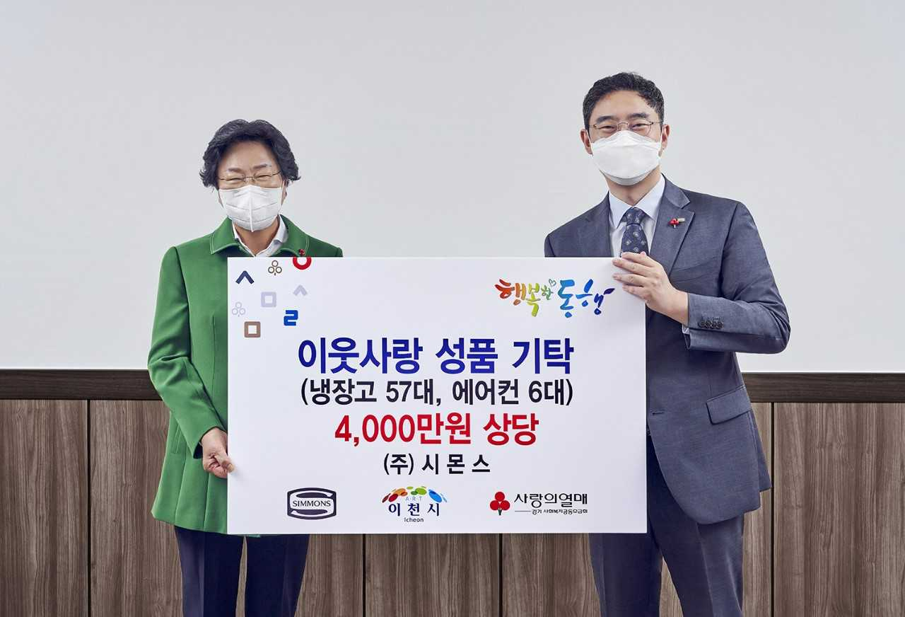 김영훈 시몬스 부사장(오른쪽)과 김경희 이천시장이 지난 7일 이천 지역 주민 대상 생활용품 지원 기탁식에서 사진촬영을 하고 있다.[시몬스 제공]