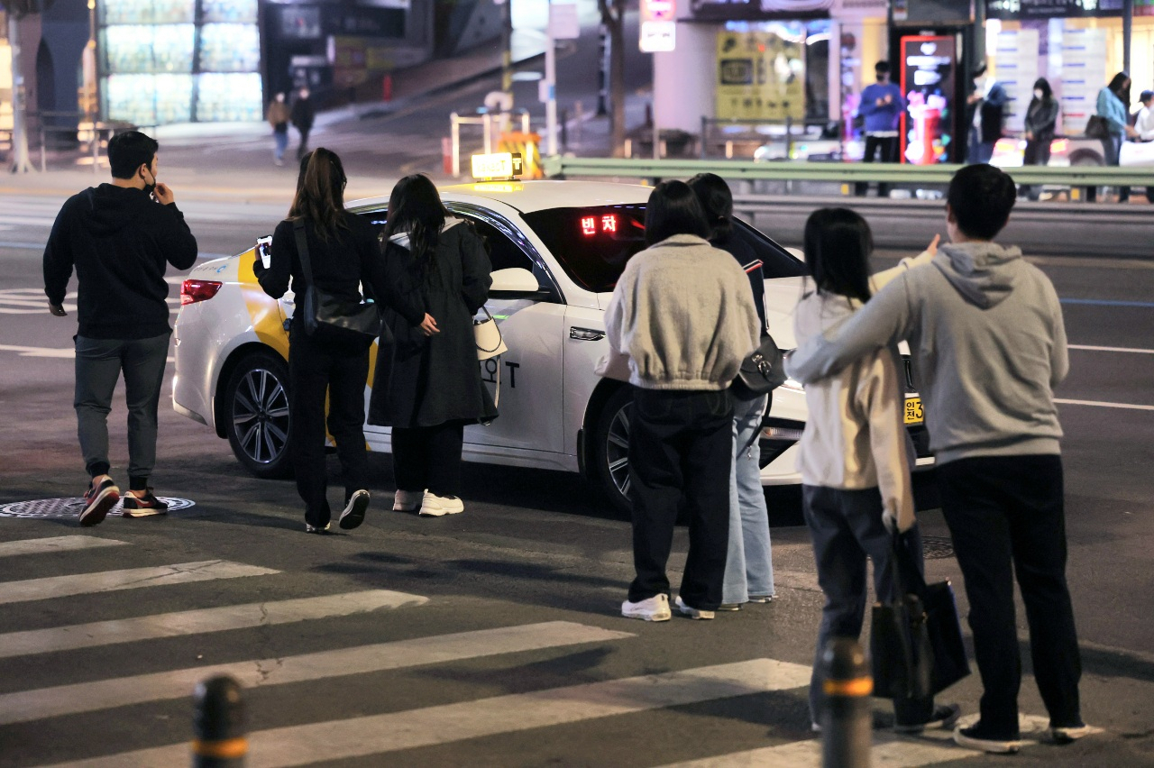 서울 강남역에서 여러 시민이 카카오 택시를 향해 모여들고 있다. [연합]