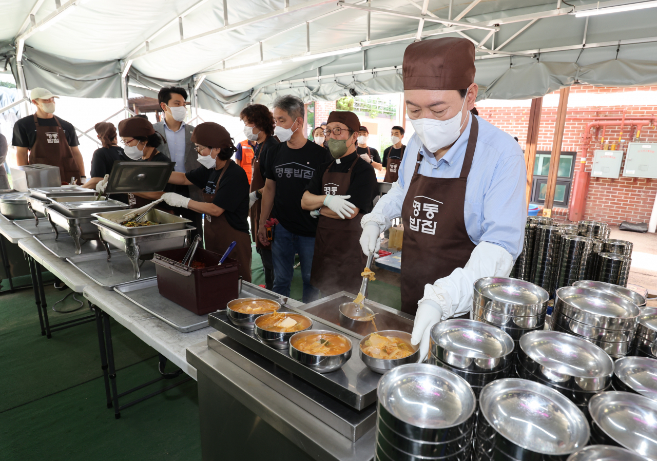 윤석열 대통령이 추석 연휴 첫날인 9일 서울 중구 명동성당 내 무료급식소인 명동밥집에서 배식 봉사를 하고 있다. [연합]