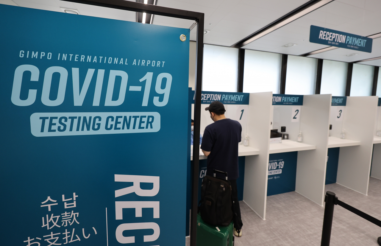 A traveler applies for a COVID-19 test at Gimpo International Airport in western Seoul on Wednesday. (Yonhap)