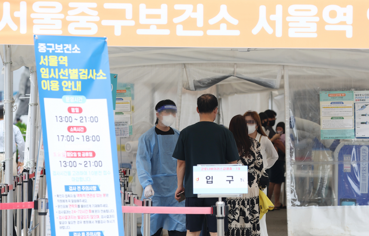 추석 연휴 사흘째인 11일 오후 서울역 앞에 마련된 코로나19 선별검사소에서 관계자가 시민을 안내하고 있다. [연합]