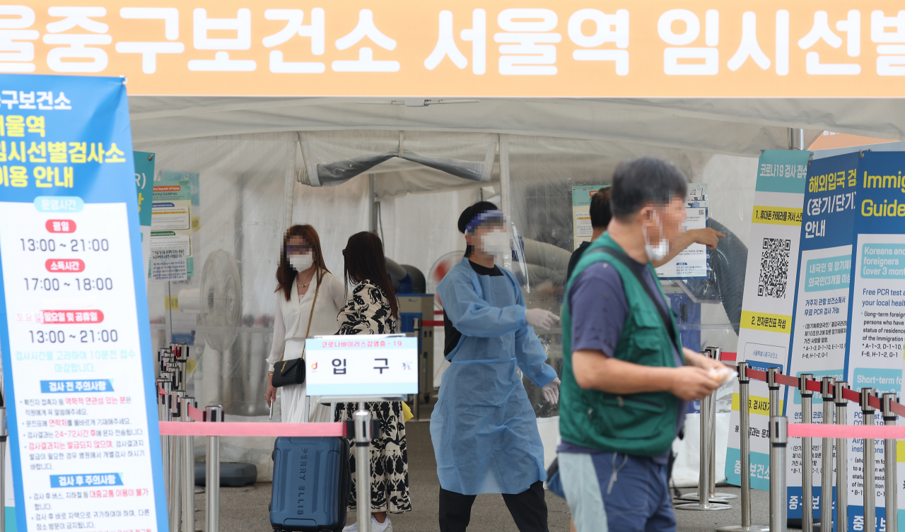 추석 연휴 사흘째인 11일 오후 서울역 앞에 마련된 코로나19 선별검사소에서 관계자가 시민을 안내하고 있다. [연합]