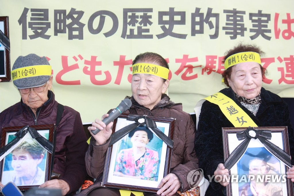 2015년 27일 정오 일본 도쿄 미나토(港)구 소재 일본 기업 후지코시(不二越) 도쿄 본사 사옥 앞에서 근로정신대 피해자 최희순(84) 할머니(가운데)가 배상을 요구하고 있다. 할머니들은 함께 법정 투쟁을 벌이다 미리 세상을 떠난 피해자들의 영정 사진을 들었다.[연합]