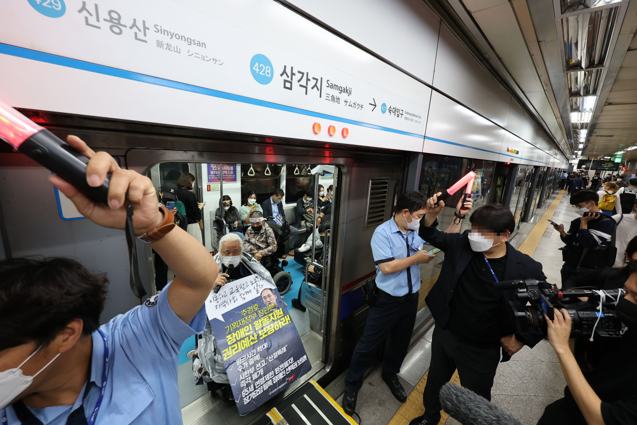 지난달 30일 오전 서울 용산구 삼각지역에서 전국장애인차별철폐연대 회원들이 장애인권리예산 보장을 촉구하며 삭발투쟁 100일차 맞이 기자회견을 한 뒤 지하철 탑승 시위를 하고 있다. [연합]