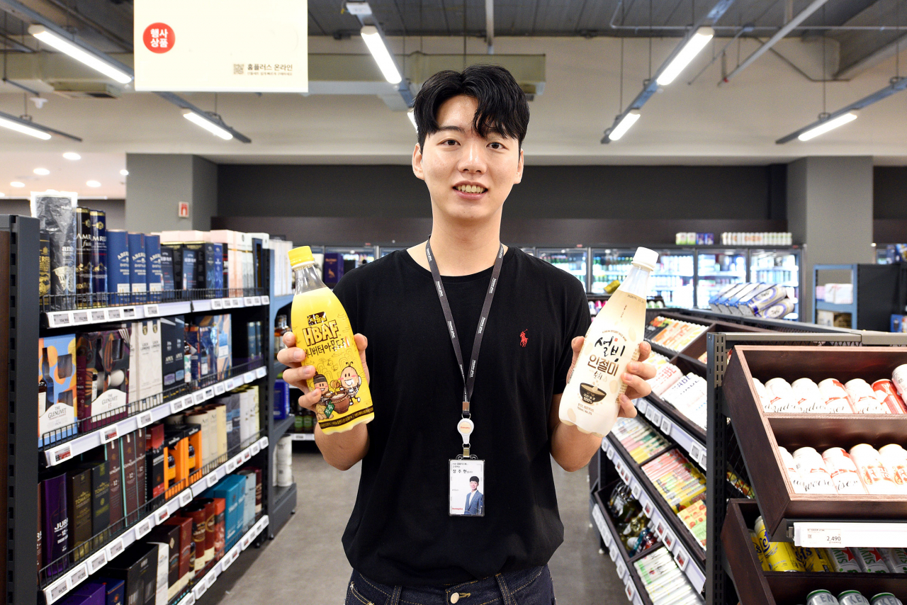 MZ막걸리를 기획한 장주현 홈플러스 차주류팀 바이어가 13일 서울 등촌동 ‘홈플러스 메가푸드마켓’ 플래그십 스토어 강서점에서 신상품 ‘바프허니버터아몬드 막걸리’(왼쪽, 노란색)를 선보이고 있다. [홈플러스 제공]