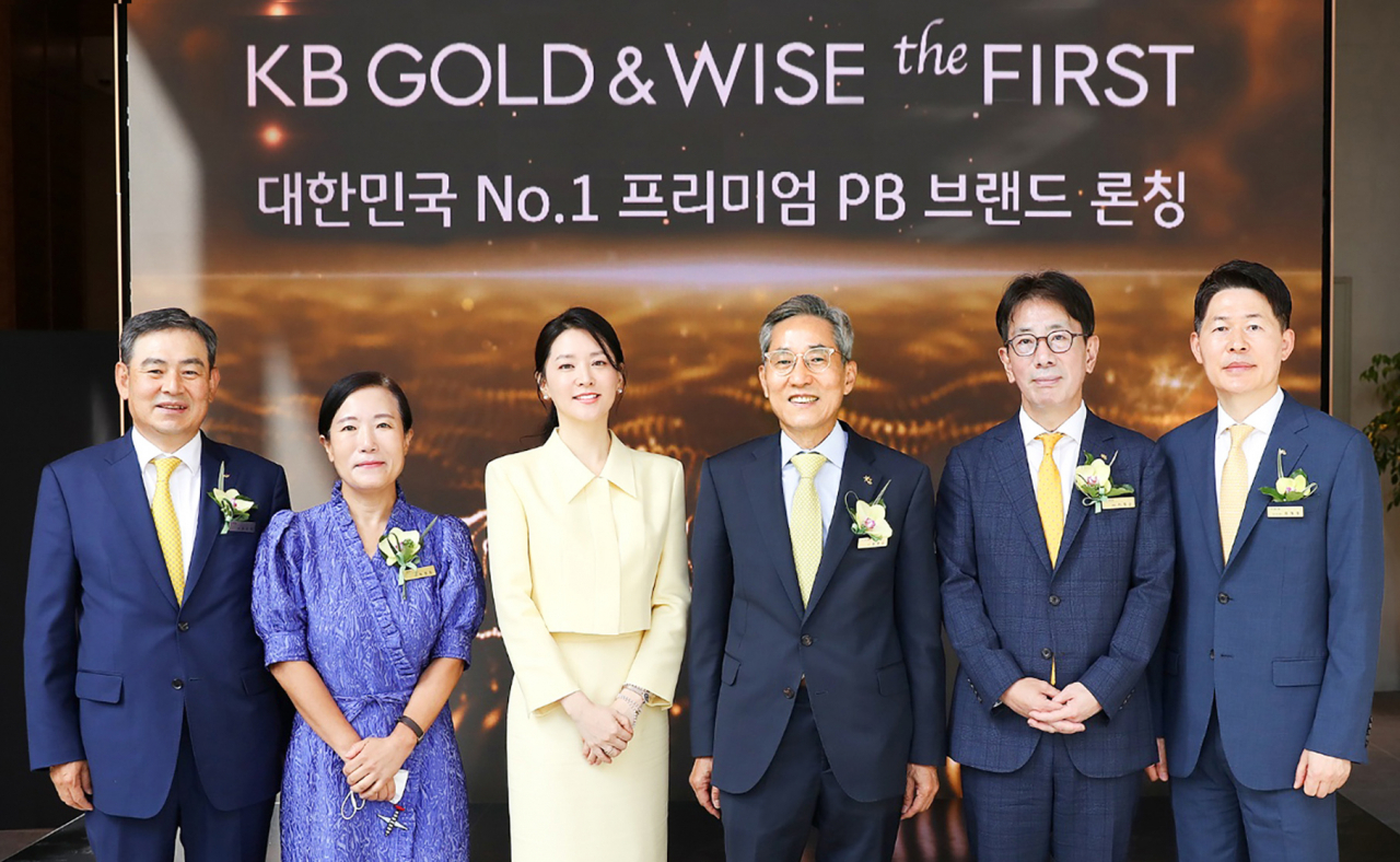 지난 6일 열린 ‘KB GOLD&WISE the FIRST’ 오픈 기념식에 참석한 KB금융그룹 윤종규 회장과 광고모델 이영애 및 관계자가 기념촬영을 하고 있다.