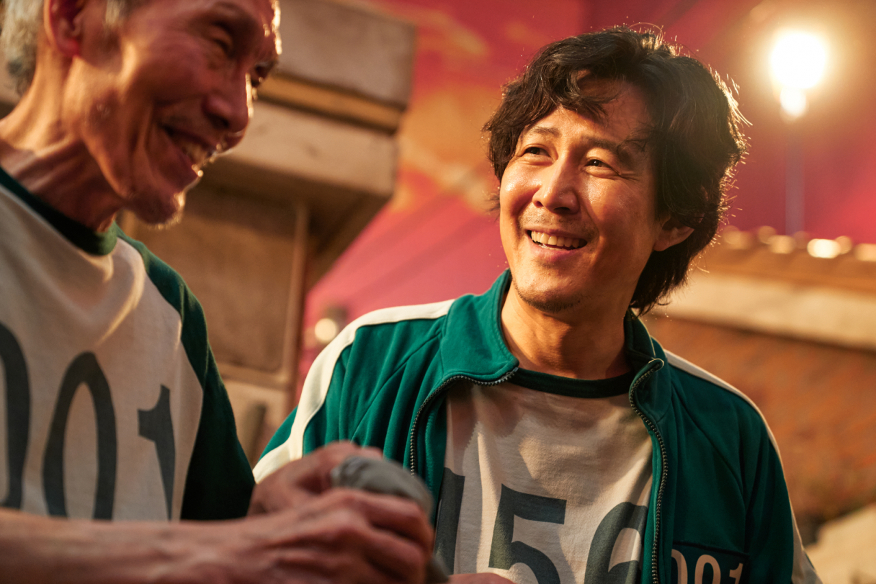 Lee Jung-jae (right) plays debt-ridden divorced father Seong Gi-hun in "Squid Game." (Netflix)