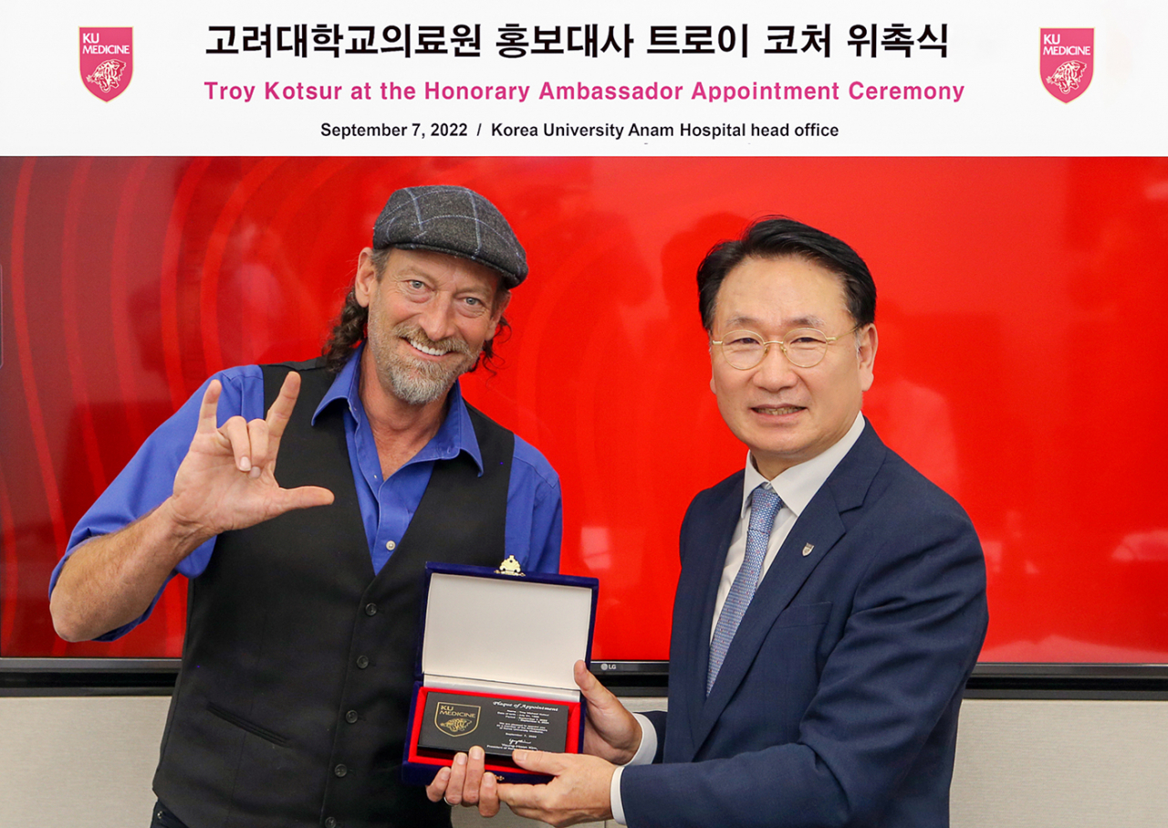 〈사진설명〉김영훈 고려대 의무부총장(우측)과 배우 트로이 코처(좌측)가 고려대학교의료원 홍보대사 위촉식에서 위촉패를 들고 기념사진을 촬영하고 있다.