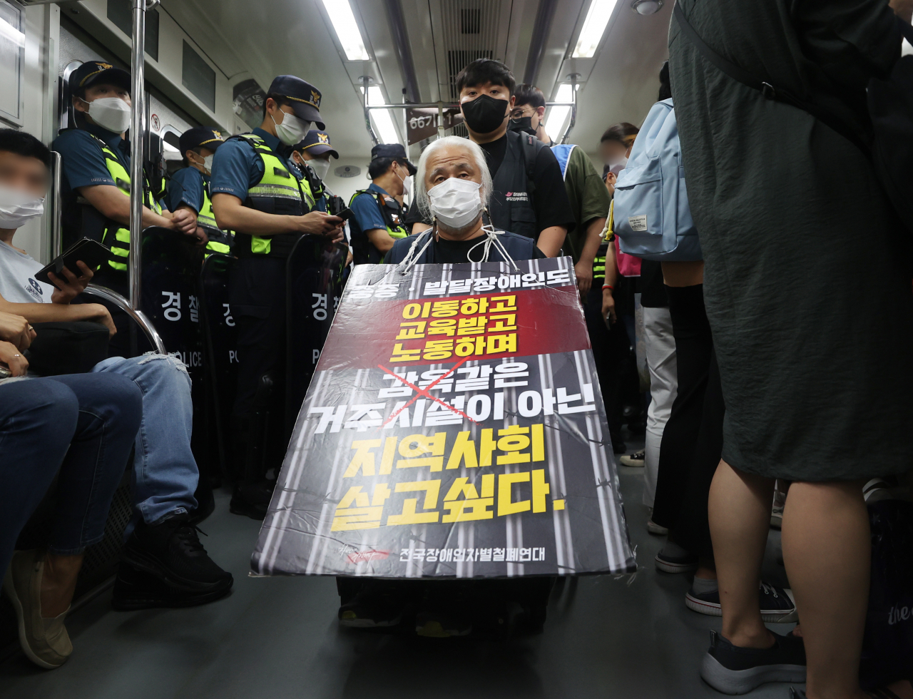 전국장애인차별철폐연대(전장연) 회원들이 13일 오전 서울 5호선 동대문역사공원역 지하철에서 장애인권리예산 삭감을 규탄하며 제36차 출근길 지하철 탑승 시위를 벌이고 있다. 전장연은 이날 오전 4호선 삼각지역에서 2개 조로 나눠 2, 4, 5, 9호선 등 지하철을 타고 국회의사당역으로 향했다. [연합]