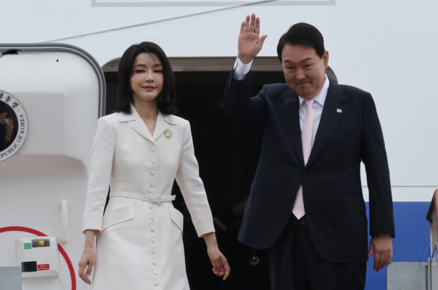 윤석열 대통령과 김건희 여사가 스페인 마드리드에서 열리는 북대서양조약기구(나토) 정상회의 참석을 위해 지난 6월27일 경기 성남 서울공항에서 공군 1호기에 올라 인사하고 있다. [연합]