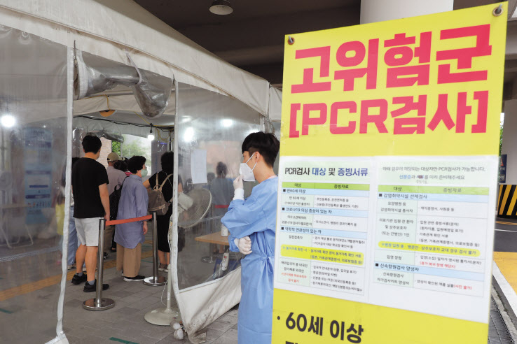 14일 오전 서울 마포구보건소 선별진료소에서 시민이 줄을 서서 코로나 검사 순서를 기다리고 있다. [연합]