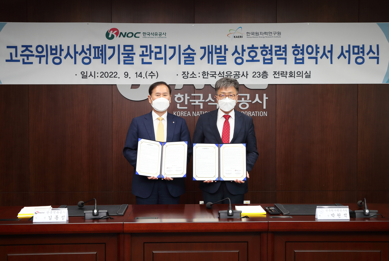 박원석(오른쪽) 한국원자력연구원 원장과 김동섭 한국석유공사 사장이 고준위방사성폐기물 관리기술 개발 상호협력 협약서를 들어 보이고 있다.[한국원자력연구원 제공]