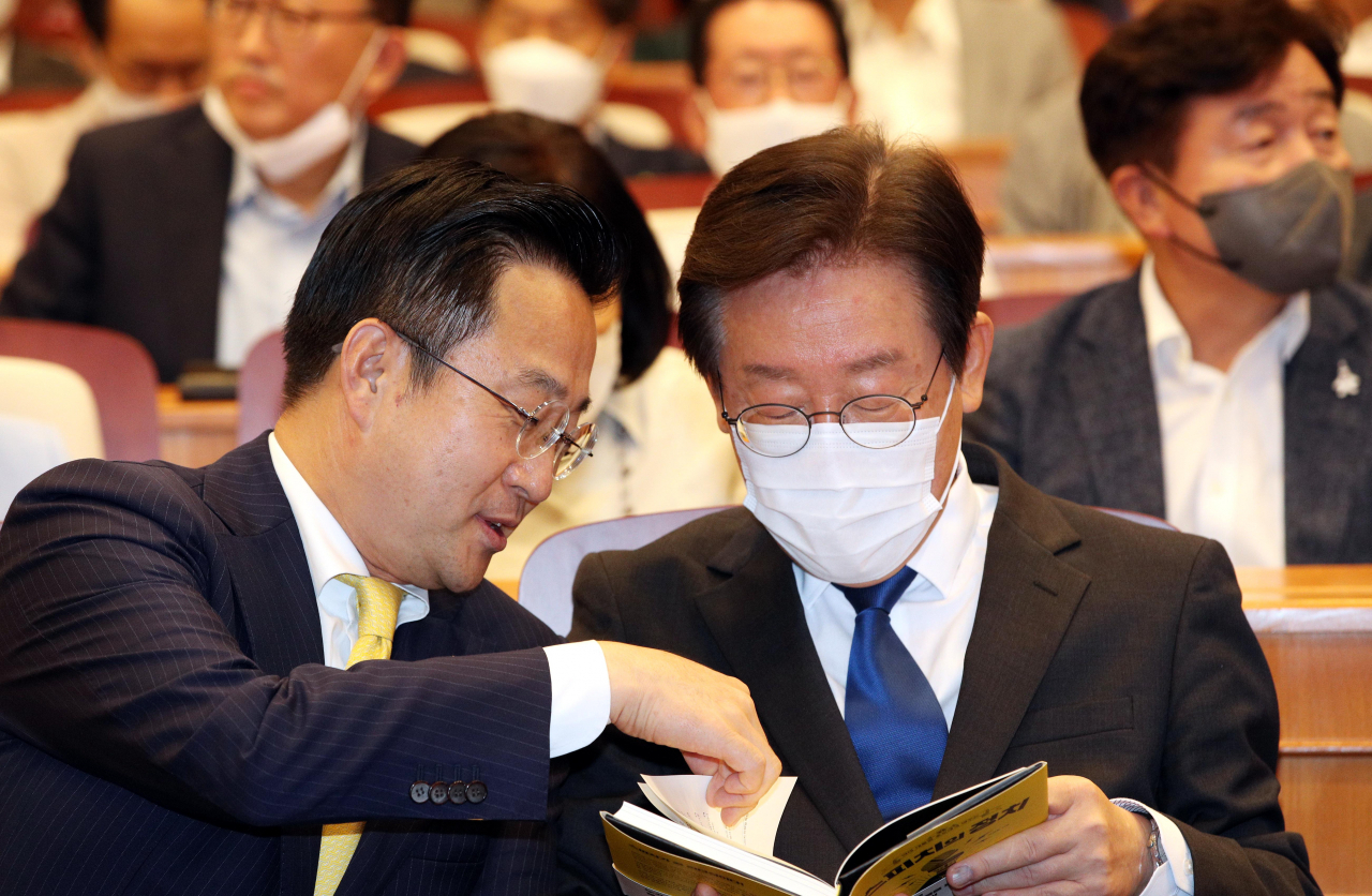 이재명 더불어민주당 당 대표 후보가 국회박물관 내 체험관에서 열린 박성준 의원의 '역대 대통령 후보에게 배우는 스피치의 정치' 출판기념회에서 박 의원으로부터 책을 소개받고 있다. [연합]