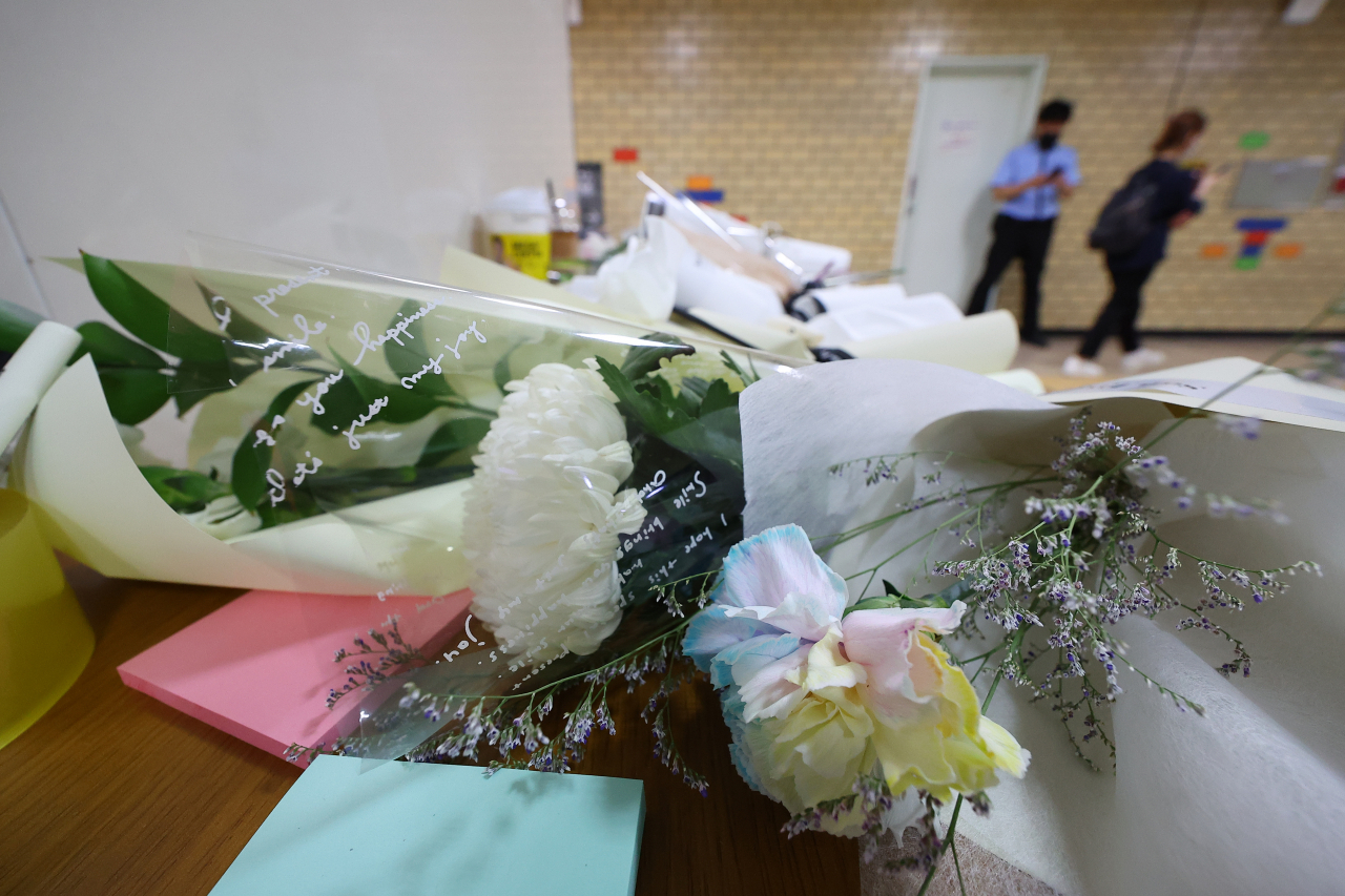‘역무원 스토킹 피살 사건’이 발생한 서울 지하철 2호선 신당역 여자화장실 입구에 마련된 추모공간에 16일 오전 국화꽃들이 놓여 있다. [연합]