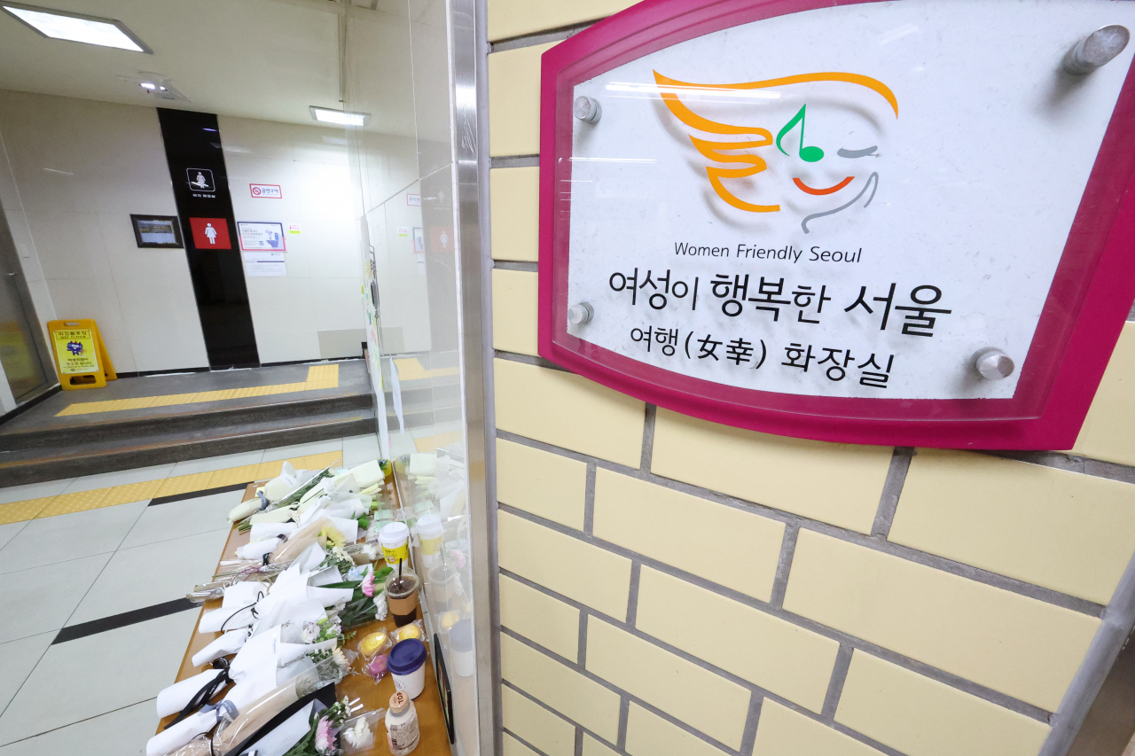 '역무원 스토킹 피살 사건'이 발생한 서울 지하철 2호선 신당역 여자화장실 입구에 마련된 추모공간에 16일 오전 국화꽃 등이 놓여 있다. [연합]