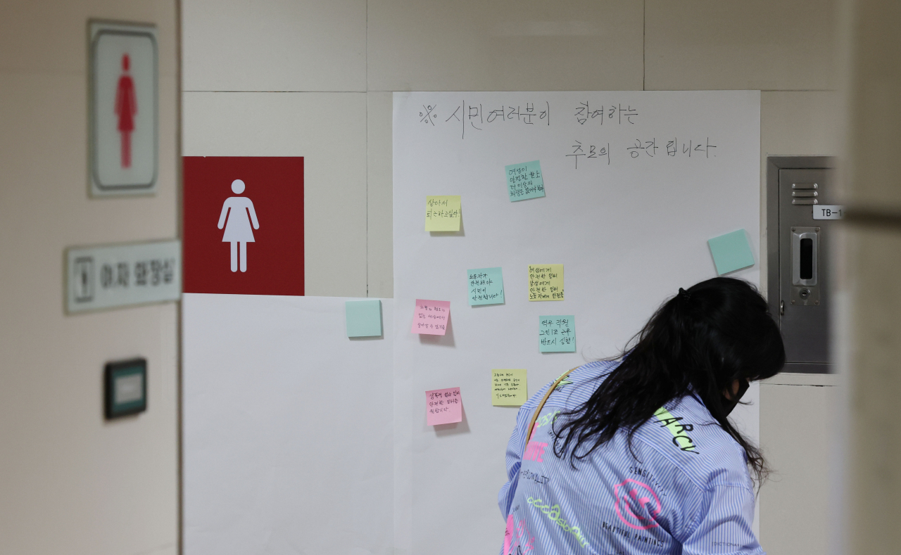 지난 15일 전 서울교통공사 직원 전모 씨가 20대 동료 여성 역무원을 뒤쫓아가 살해한 사건이 발생한 서울 지하철 2호선 신당역 여자화장실 입구에 마련된 추모공간에서 시민들이 추모 메시지를 쓰고 있다. [연합]