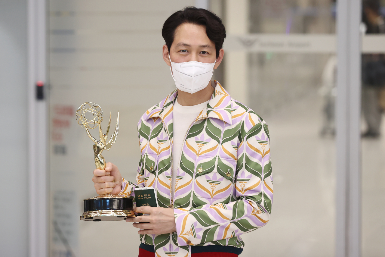넷플릭스 한국 시리즈 '오징어 게임'으로 제74회 에미상에서 남우주연상을 받은 배우 이정재가 18일 오후 인천국제공항 제2터미널로 귀국해 트로피를 들어보이고 있다. [연합]