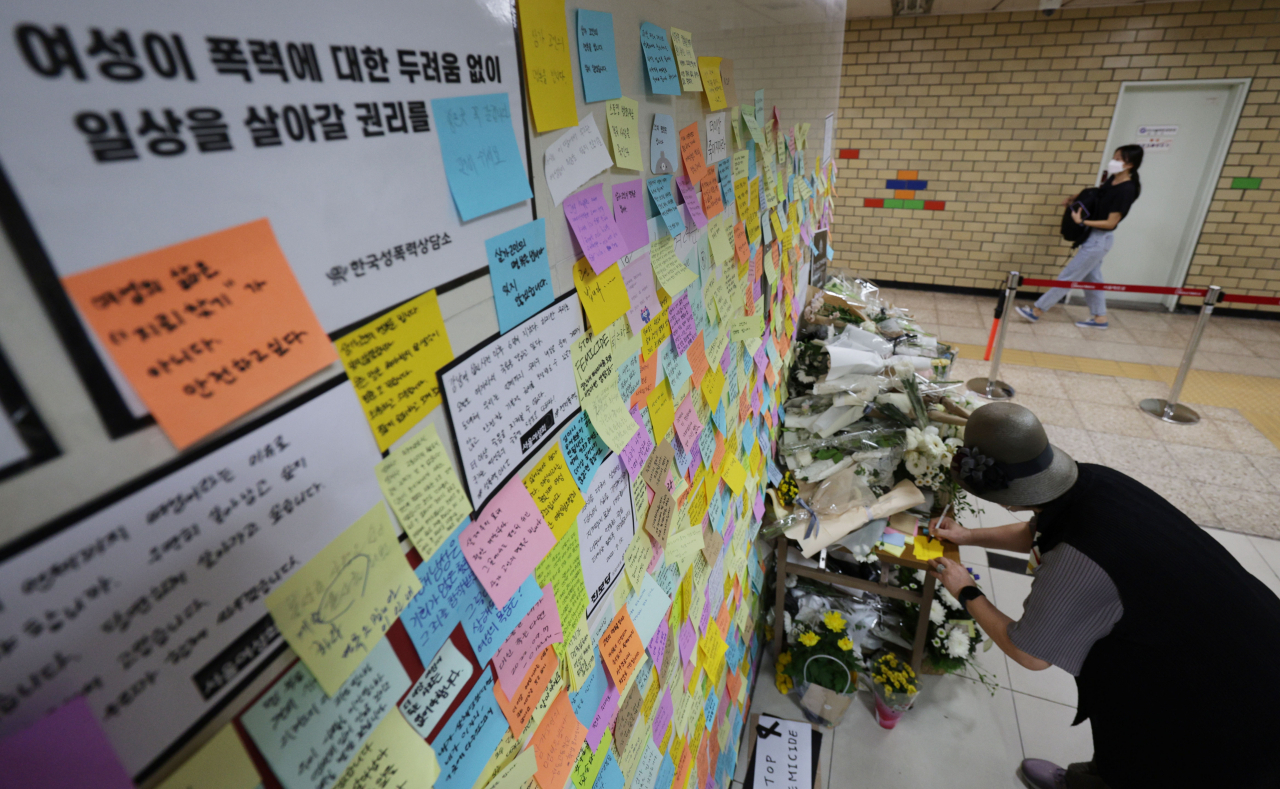 지난 18일 한 시민이 ‘역무원 스토킹 피살사건’이 발생한 서울 지하철 2호선 신당역 여자화장실 입구에 마련된 추모공간에서 추모 메시지를 남기고 있다. [연합]