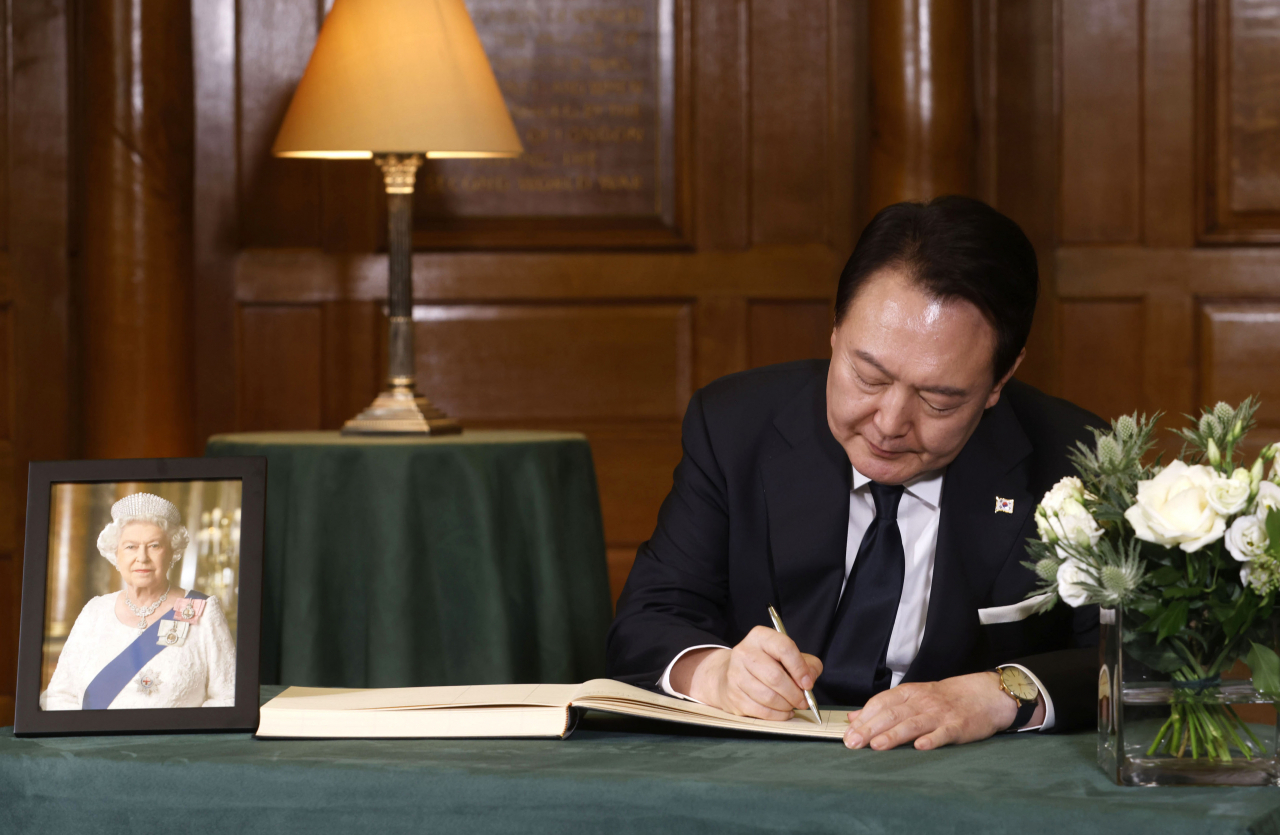 윤석열 대통령이 19일 영국 런던 웨스트민스터 사원에서 엄수된 엘리자베스 2세 여왕 장례식에 참석한 뒤 조문록을 작성하고 있다. [영국 외교부 플리커 계정] [연합]