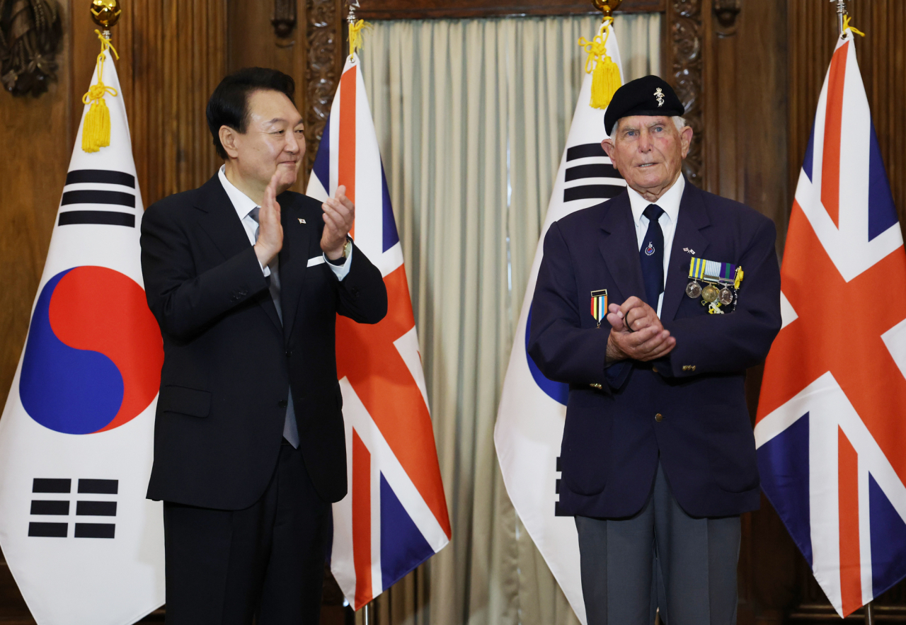 윤석열 대통령이 19일(현지시간) 영국 런던 한 호텔에서 빅터 스위프트 영국 한국전 참전용사협회 회장에게 국민포장을 수여한 뒤 박수치고 있다. 빅터 스위프트 회장은 1934년생으로 당시 영국 육군 왕립 전자기계 공병군단 소속으로 한국전에 참전했다. [연합]