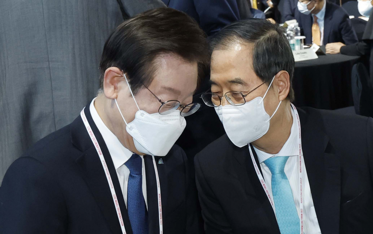 더불어민주당 이재명 대표와 한덕수 국무총리가 20일 오전 서울 중구 장충체육관에서 열린 2022 세계지식포럼 개막식에서 대화하고 있다. [연합]