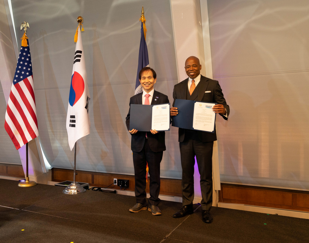 이광형(왼쪽) KAIST 총장과 에릭 애덤스 뉴욕시장이 협력협정서를 들어보이고 있다. [KAIST-NYU 제공]