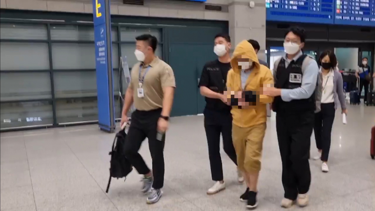 경찰청이 23일 새벽 인천국제공항을 통해 140억원대 가상자산 해킹 피의자 A씨를 송환하고 있다. [경찰청 제공]