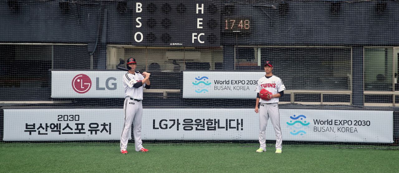 LG트윈스 선수들이 ‘2030 부산세계박람회 유치, LG가 응원합니다!’는 회전 광고판 앞에서 훈련을 하고 있다. [㈜LG 제공]