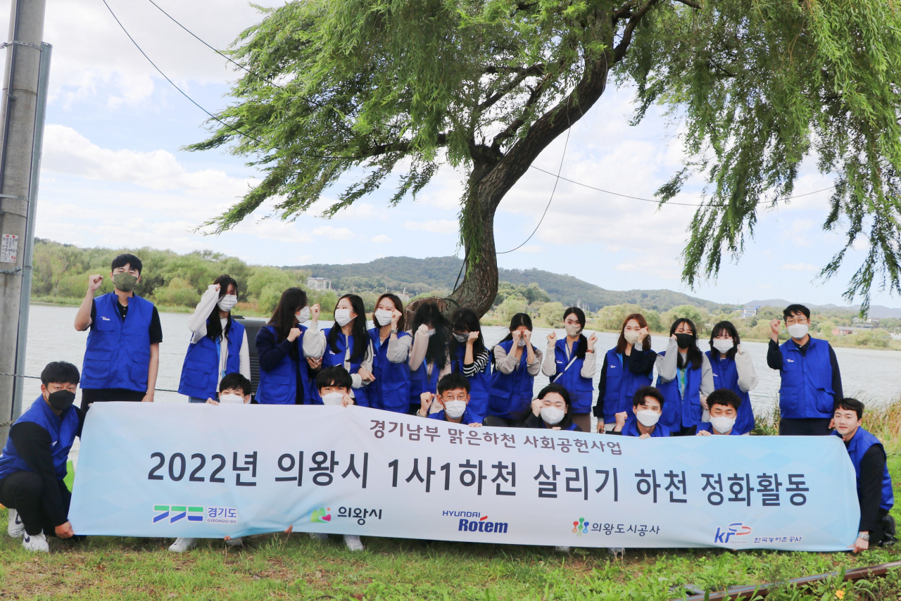 지난 23일 현대로템 임직원들이 경기도 의왕시 왕송호수 및 금천천 일대에서 환경정화 활동 후 기념촬영을 하고 있다.