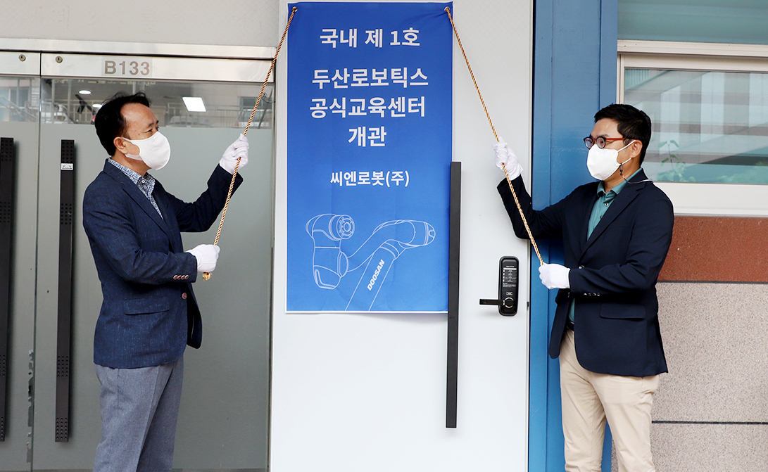 류정훈(오른쪽) 두산로보틱스 대표와 김익수 씨엔로봇 대표가 공식교육센터 오픈 기념식을 진행하고 있다. [두산 제공]