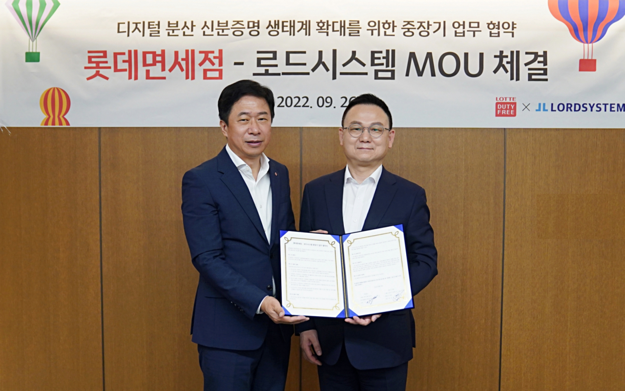 롯데면세점이 시내면세점에서 실물 여권을 대체할 수 있는 ‘디지털 분산 신분증명’을 도입하기 위해 로드시스템과 MOU를 체결했다고 27일 밝혔다. 사진은 26일 이갑 롯데면세점 대표이사(사진 좌측)와 장양호 로드시스템 대표이사가 기념사진을 촬영하고 있는 모습. [롯데면세점 제공]