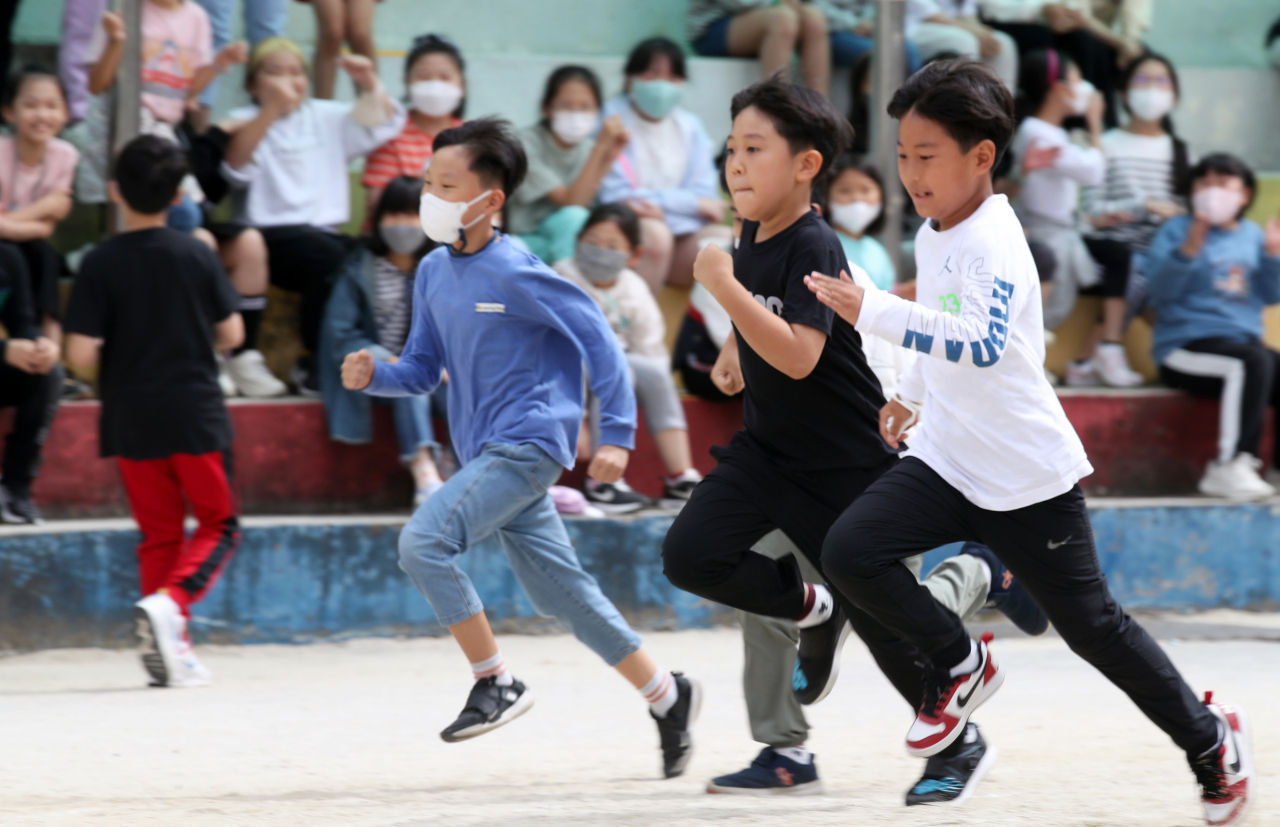 Students without masks run during a field day at an elementary school in Gwangju, 268 kilometers south of Seoul, on Monday. South Korea lifted all outdoor mask mandates the same day as the country is "clearly overcoming" a resurgence in COVID-19 cases, but the indoor mask mandate will remain in place. (Yonhap)
