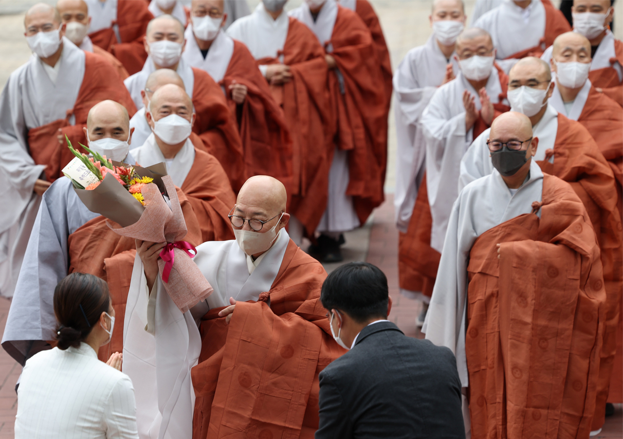 Ven. Jinwoo (C), new executive chief of the Jogye Order, receives a bouquet at the Jogye Temple in Seoul on Wednesday. (Yonhap)