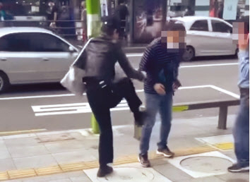 지난 26일 서울 강북구 수유역 일대에서 20대 여성이 흡연을 제지하던 공무직 소속 직원을 폭행하고 있다. [온라인 커뮤니티 캡처]