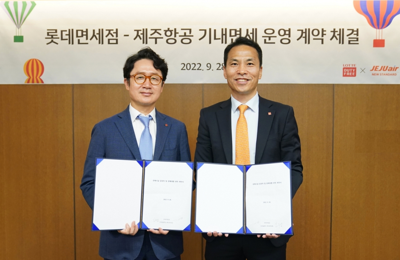 롯데면세점이 국내 1위 LCC사업자인 제주항공의 기내면세점 사업권을 획득했다고 29일 밝혔다. 지난 28일 열린 계약 체결식에서 김주남 롯데면세점 한국사업본부장(사진 좌측)과 고경표 제주항공 커머셜본부장이 기념사진을 촬영하고 있는 모습.[롯데면세점 제공]