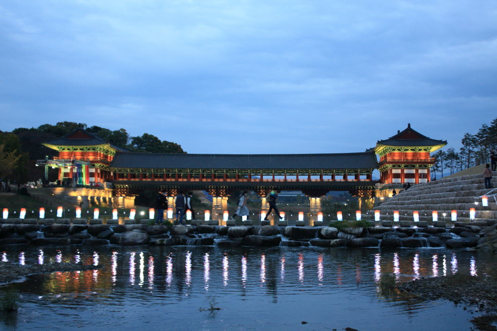 Visitors cross the stepping-stones next to Woljeonggyo Bridge at the last year‘s Cultural Heritage Night Tour in Gyeongju, North Gyeongsang Province. (Gyeongju City)