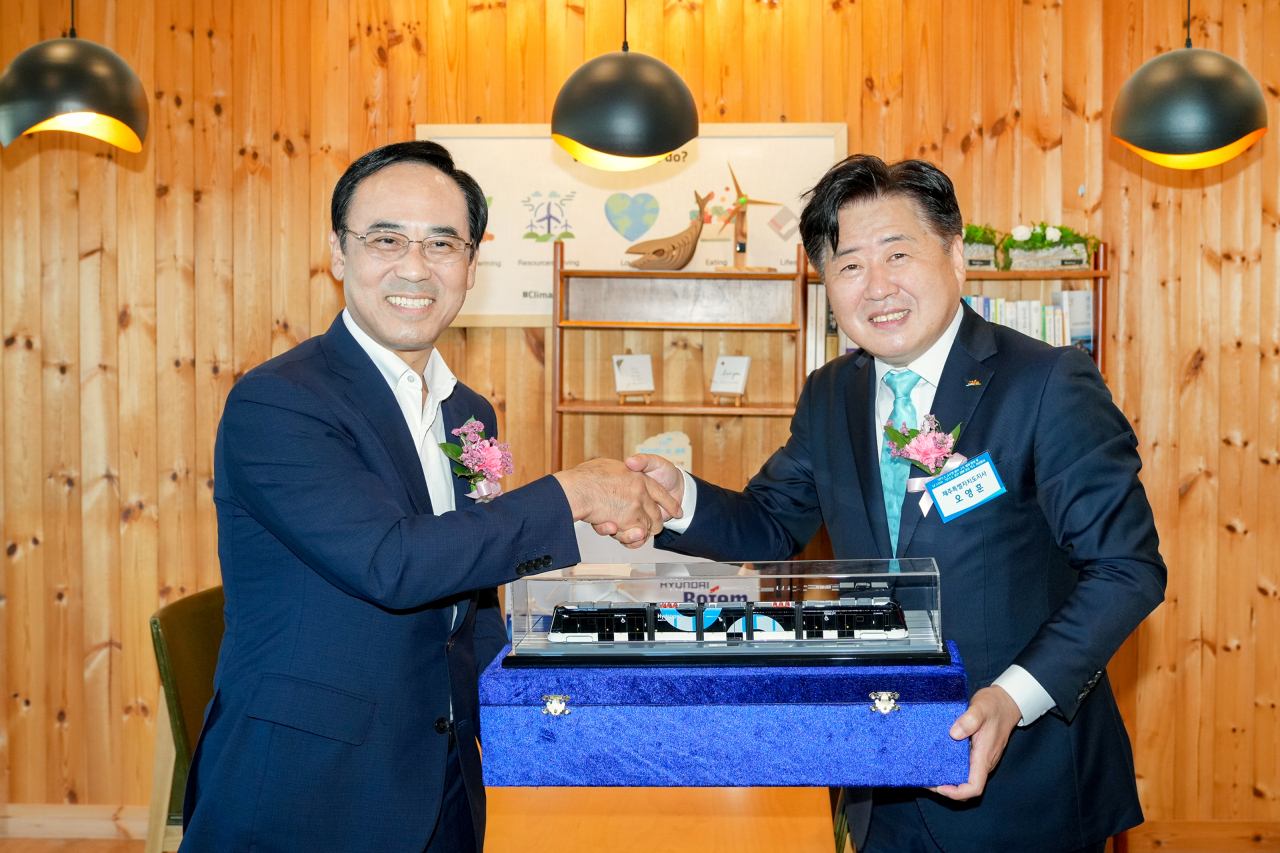 오영훈(오른쪽) 제주도지사와 이용배 현대로템 사장이 현대로템 수소전기트램 모형을 들고 기념촬영을 하는 모습. [현대로템 제공]