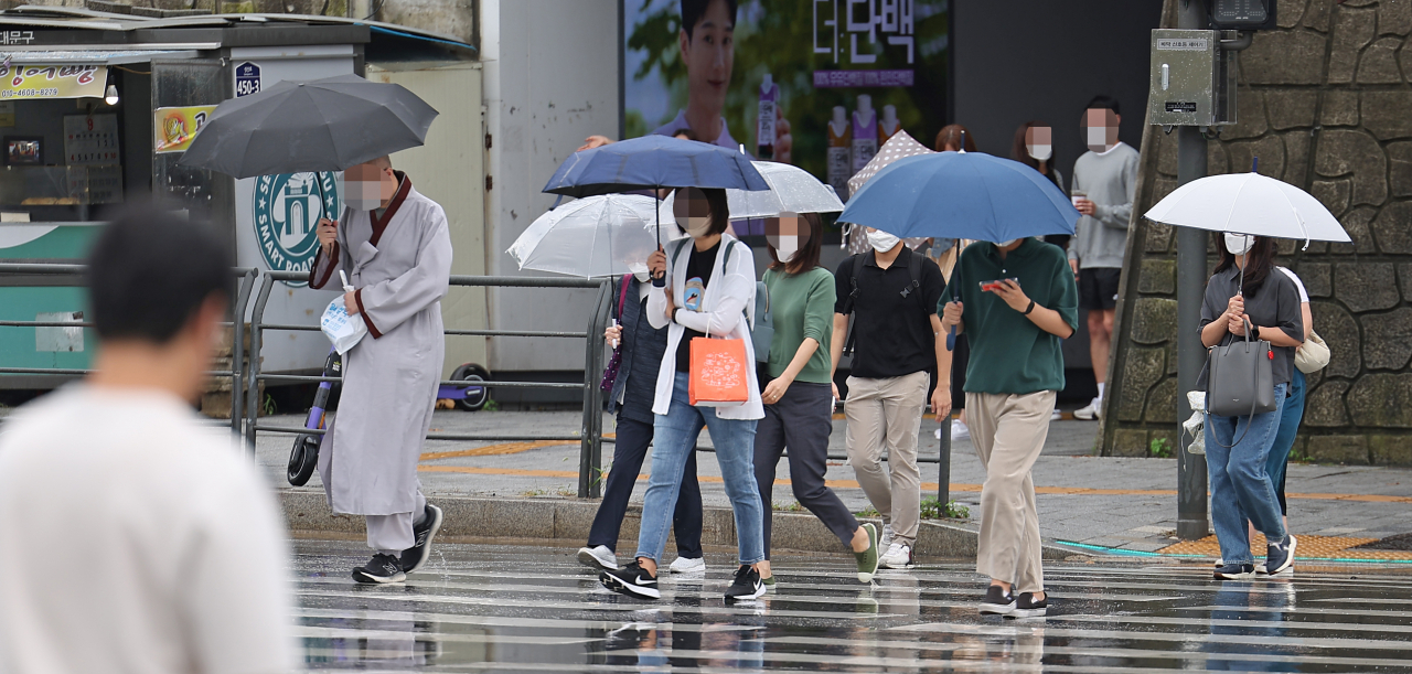 서울 서대문구 연세대 앞 횡단보도에서 우산을 쓴 시민들이 길을 지나고 있다. [연합]