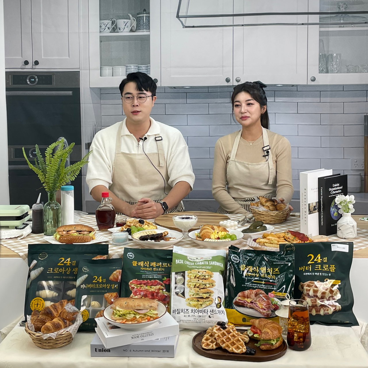 지난달 27일 신세계푸드가 네이버 쇼핑 라이브에서 진행한 홈베이커리 라이브 방송에서 쇼호스트들이 밀크앤허니 크루아상 생지를 비롯한 다양한 제품들을 소개하고 있다. [신세계푸드 제공]