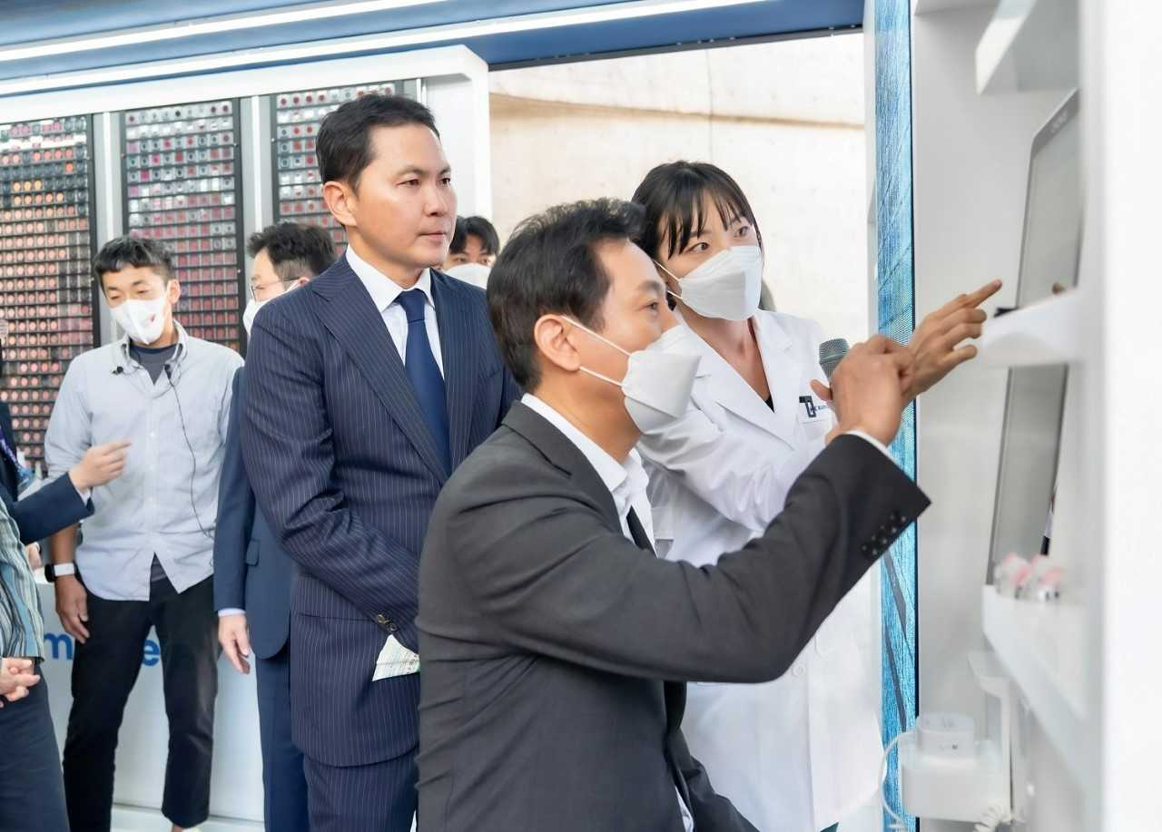 지난달 30일 열린 ‘2022 서울뷰티위크’의 한국콜마 부스에서 오세훈 서울시장(가운데)이 윤상현 한국콜마 부회장(왼쪽) 등으로부터 피부진단 서비스를 안내받고 있다.[한국콜마 제공]