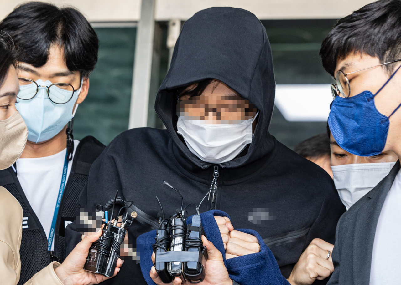 자신이 거주하던 고시원의 주인인 70대 여성을 살해한 혐의를 받는 30대 남성 A씨가 지난달 29일 오후 서울중앙지법에서 열린 구속 전 피의자 심문(영장실질심사)을 받기 위해 서울 관악경찰서를 빠져나오다 취재진의 질문을 받고 있다. [연합]