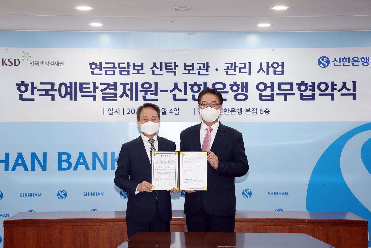 (왼쪽)진옥동 신한은행장과 이명호 한국예탁결제원 사장이 지난 4일 업무협약식 체결 뒤 기념촬영을 하고 있는 모습. [한국예탁결제원 제공]