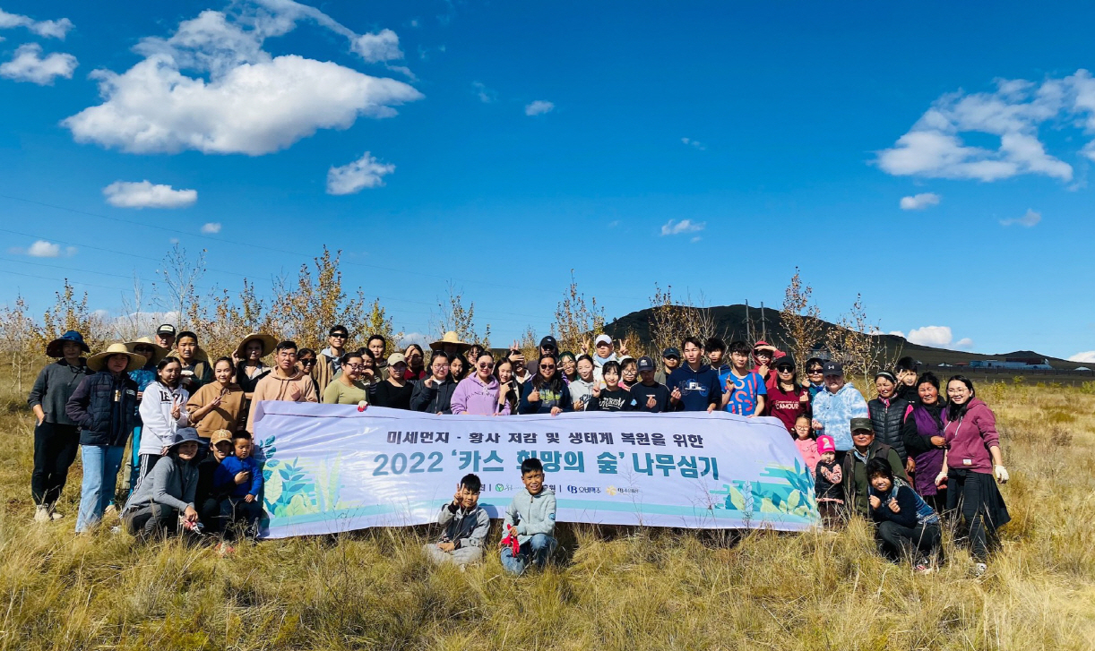 몽골 학생 봉사단이 몽골 북동부 에르덴솜 지역에서 나무심기 봉사활동 마치고 단체 사진을 찍고 있다. [오비맥주 제공]