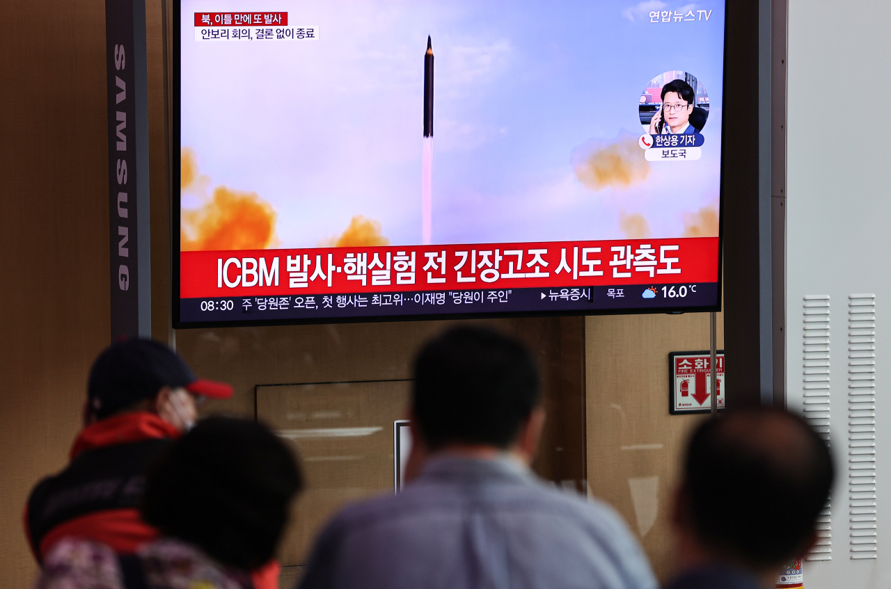 Passersby watch a TV report of North Korea's missile launch at Seoul Station on Thursday. (Yonhap)