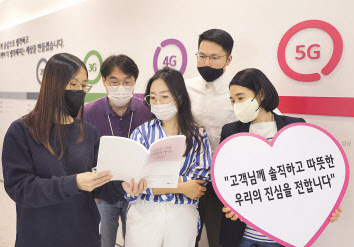 ‘고객 언어 가이드북 2.0’을 기획한 임직원들이 가이드북을 읽고 있는 모습. [LG유플러스 제공]