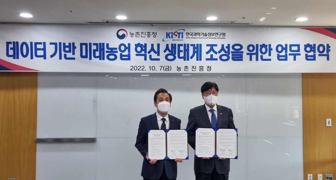 김재수(왼쪽) KISTI 원장과 조재호 농촌진흥청 청장이 업무협약서를 들어 보이고 있다.[KISTI 제공]