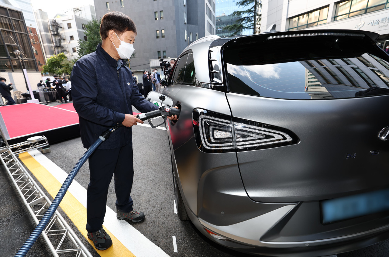 An official shows how to charge a hydrogen powered car at the