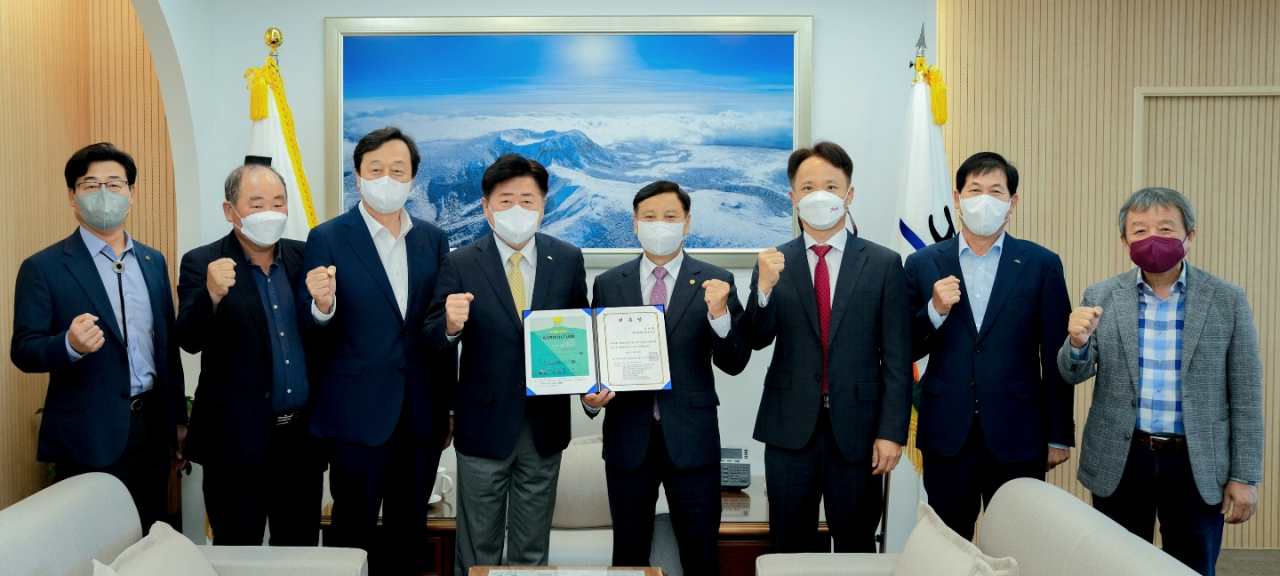 Governor Oh Young-hun (fourth from left) and co-chairpersons of the organizing committee for the first electric and autonomous agriculture expo pose for a photo during a commissioning ceremony in Jeju, Sept. 30. (IEVE)