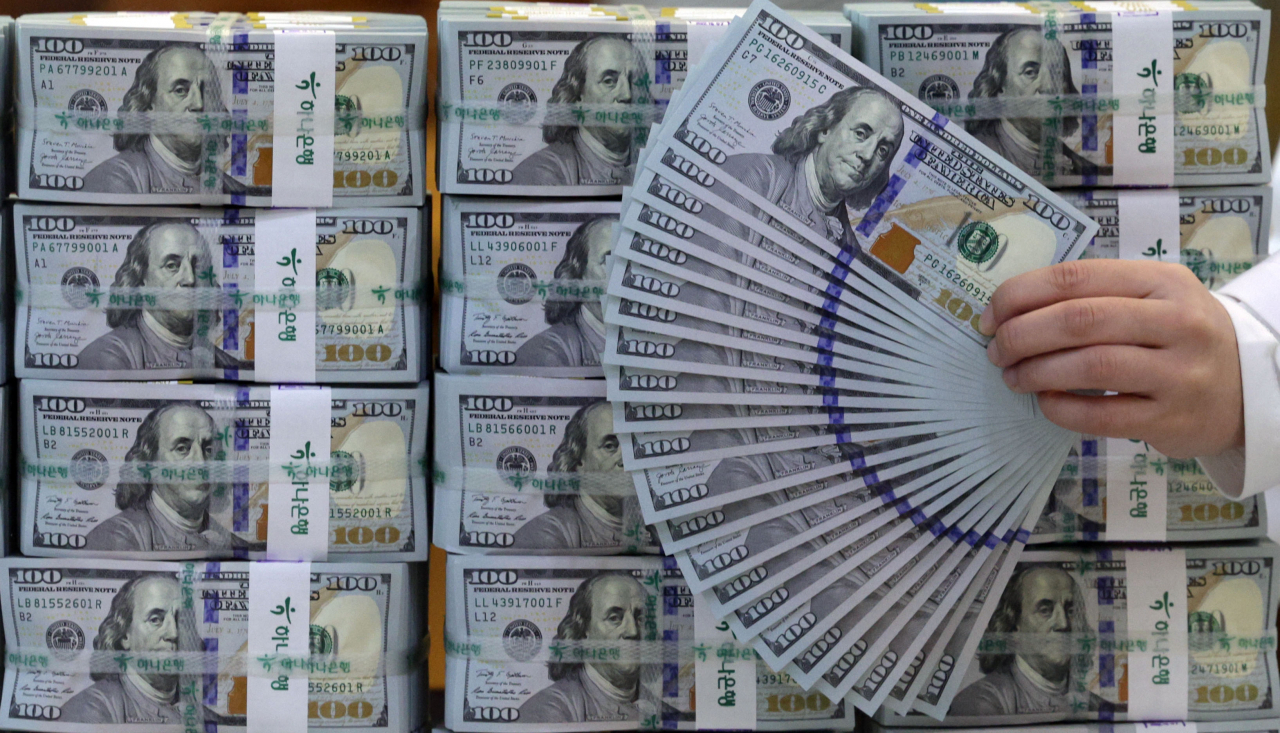 A staff from Hana Bank at Euljiro, central Seoul, organizes several stacks of dollar bills on Friday. (Yonhap)