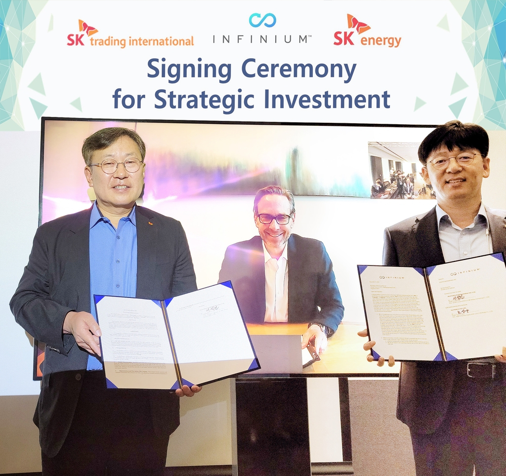 SK Trading International CEO and President Suh Sok-won (L) and Noh Sang-ku (R), a senior director at SK Energy, pose for a photo with Robert Schuetzle, CEO of Infinium, joining the signing ceremony via virtual link, on Sept. 30, in this photo provided by SK Innovation, the parent firm of the two SK units, on Wednesday. (SK Innovation)